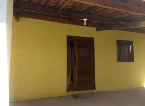 a yellow wall with a door in a room at Casa na Serra in Bezerros +1 photo