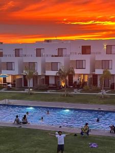a group of people standing around a swimming pool at sunset at Casa Cordova in Alpuyeca