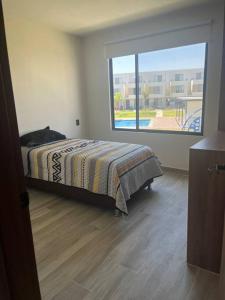 a bedroom with a bed and a large window at Casa Cordova in Alpuyeca +18 photos