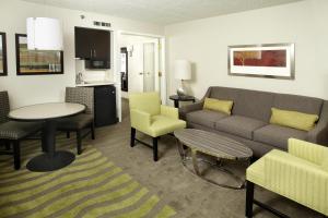 Holiday Inn Wilkes Barre - East Mountain, an IHG Hotel في ويلكس-بار: غرفة معيشة مع أريكة وطاولة وكراسي