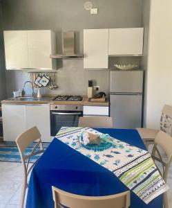 a kitchen with a table with a blue table cloth on it at Casa ORI in Montesilvano