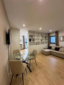 Una sala de estar con una mesa de cristal y sillas. en Living Funchal V, en Funchal