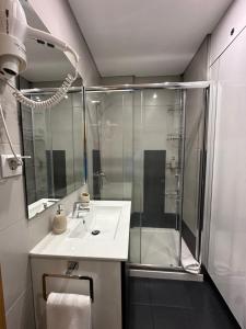 Un baño con ducha y lavabo blanco. en Living Funchal V, en Funchal 14 fotos más