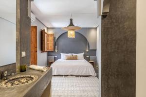 a bedroom with a bed and a sink and a mirror at Riad Macan Exclusive and Trendy Chich Breakfast incl in Marrakech