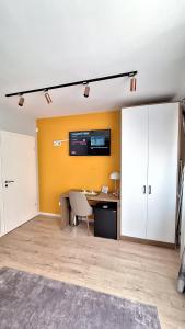 an empty room with a desk and a yellow wall at Avenue Apartment in Pristina
