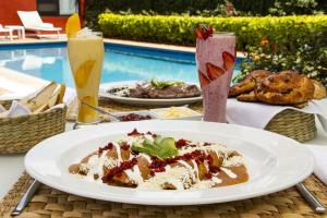 a table with a plate of food and two drinks at Quinta Elvira in Cuernavaca