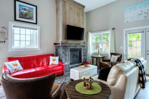a living room with a red couch and a fireplace at Sandy Cove Cottage in Crystal Beach