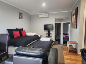a living room with a black couch and red pillows at Plateau Lodge in National Park