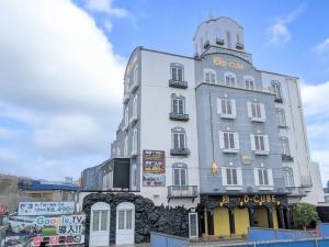 a tall white building with a sign on it at HOTEL D-CUBE 明石店 in Higashi-futami