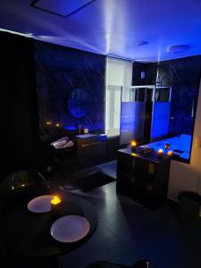 a dark room with a bathroom with two sinks and a tub at La Suite Gold Wellness Jacuzzi & Sauna in Seraing