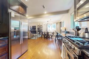 Il comprend une cuisine équipée d'un réfrigérateur en acier inoxydable et une salle à manger. dans l'établissement Cellador Charms, à South Lake Tahoe