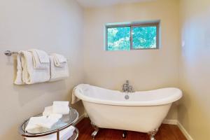 une baignoire blanche dans une salle de bains avec fenêtre dans l'établissement Cellador Charms, à South Lake Tahoe 14 autres photos