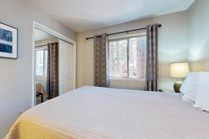 une chambre avec un grand lit blanc et une fenêtre dans l'établissement Cellador Charms, à South Lake Tahoe