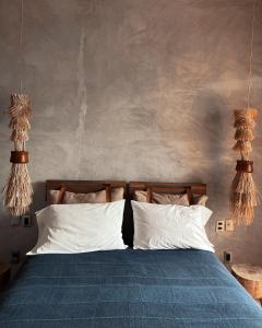 a bedroom with a bed with white pillows at Monte Uzulu Boutique Hotel in San Agustinillo