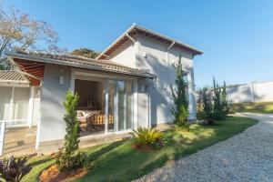 a white house with a patio and a driveway at Casa para Locação Terras de São Francisco! in Andradas +59 photos