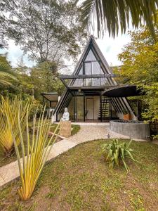 a house with a black roof with a courtyard at Intrepido Glamping in Chinchiná