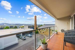 a balcony with a view of a city at City fringe modern apartment with car parking in Hobart