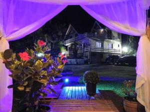 a backyard altar with purple drapes and flowers at Casa do Papai in Campos do Jordão