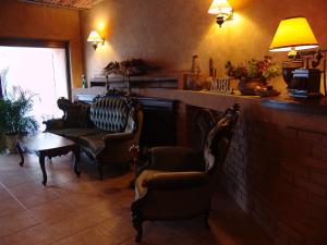 a waiting room with chairs and a table and lamps at Hotel Bella Muzica in Braşov