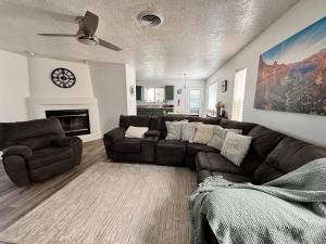 法明顿Casa Uva Beautiful Family Retreat with pool and views的带棕色沙发和壁炉的客厅
