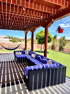 法明顿Casa Uva Beautiful Family Retreat with pool and views的带秋千的凉亭下的蓝色沙发