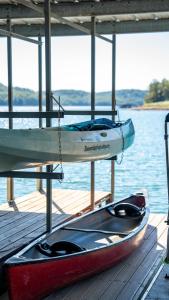 a boat sitting on a dock next to the water at Beaver Lakefront Cabins - Couples Only Getaways in Eureka Springs