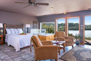 a bedroom with a bed with a tub and chairs at Beaver Lakefront Cabins - Couples Only Getaways in Eureka Springs