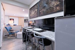 a kitchen with a counter and a bar with stools at Depa Ejecutivo Con Vista en Corazon de DGO in Durango