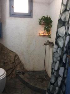 a bathroom with a toilet and a window at Summer Stoned Maisonette in Kondiás