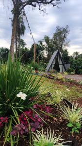 a garden with flowers and a tent in the background at Chalé das Laranjeiras in Planalto
