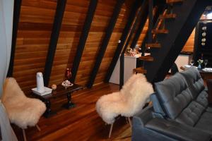 a living room with a couch and two chairs and a table at Chalé das Laranjeiras in Planalto