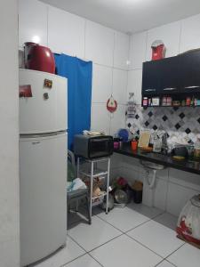a kitchen with a refrigerator and a counter with a sink at Casa em campina grande in Campina Grande