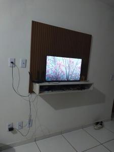 a flat screen tv sitting on a shelf in a room at Casa em campina grande in Campina Grande