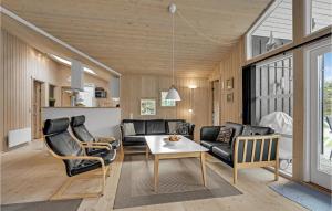 a living room with a couch and a table at Holiday Home Jægerens Vej in Blokhus