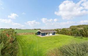 a small house in the middle of a grassy field at Lovely Home In Knebel With Wifi in Knebel +16 photos