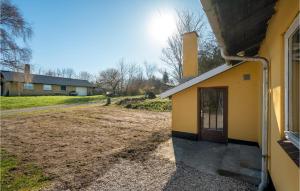 un edificio giallo con una porta accanto a una strada sterrata di 3 Bedroom Awesome Home In Thisted a Thisted Altre 17 foto