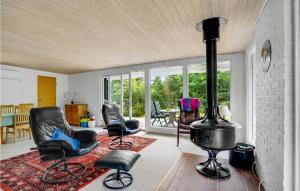 sala de estar con estufa de leña y sillas en Gorgeous Home In Blåvand With Wifi, en Blåvand