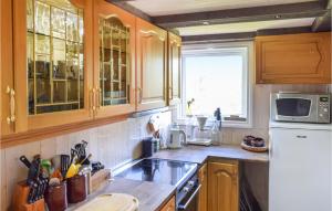 una cucina con mobili in legno e un frigorifero bianco di Stunning Home In Haulandshella a Tveitevåg