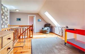 una camera mansardata con scala e tavolo rosso di Lovely Home In Kolobrzeg With Kitchen a Kołobrzeg