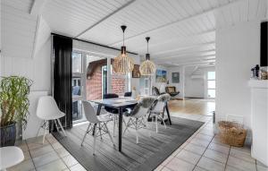 ブラーバンドにあるAmazing Home In Blåvand With Kitchenのテーブルと椅子のあるダイニングルームとリビングルーム