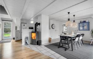 ブラーバンドにあるAmazing Home In Blåvand With Kitchenのキッチン、ダイニングルーム(テーブル、暖炉付)