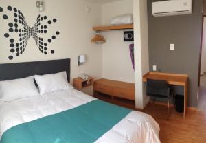 una camera con letto e scrivania di Hotel Dajana Boulevard a León
