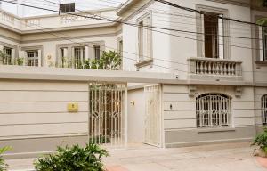 a white building with gates and windows at Hotel Casa Cuenca in Mexico City