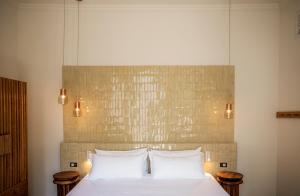 a bedroom with a white bed with two tables at Hotel Casa Cuenca in Mexico City