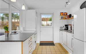 una cucina con armadi bianchi, una finestra e una porta di Holiday Home Egevej Broager a Broager Altre 16 foto