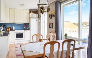a kitchen with a table and chairs and a large window at Lovely Home In Vedavågen With Wifi in Vedavågen
