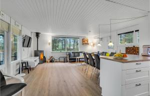 イェリングにあるAwesome Home In Hjørring With Wifiのテーブルと椅子のあるキッチンとリビングルーム