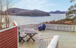 a table and chairs on a balcony with a view of the water at Holiday Home Lyngdal Bordvik in Belland