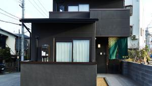a black house with a door on a street at Rikyuan Kyoto Nishikyogoku in Kyoto