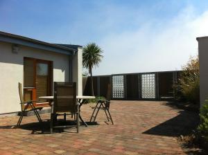 um pátio com uma mesa e cadeiras em frente a uma casa em Bearlough Self Catering Holiday Home em Rosslare